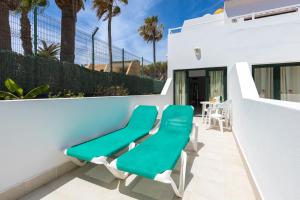 a pair of green lounge chairs on a balcony at Apartamentos Erika - Adults Only in Corralejo
