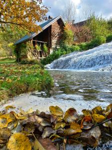 a cabin next to a river with a waterfall at Janjske otoke - smještaj na selu (Milorad Piljić) in Šipovo