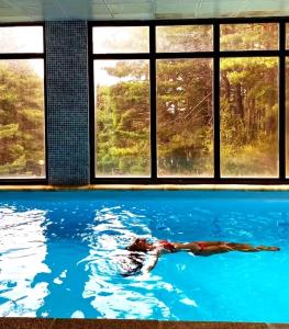 a person swimming in a pool in front of a window at Ecológico en plena naturaleza in Riaza