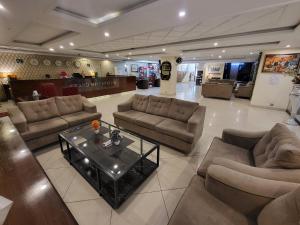 uma sala de estar com sofás e uma mesa de centro em Grand Millennium Hotel em Lahore