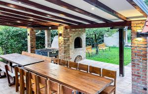 patio z drewnianym stołem i kamiennym kominkiem w obiekcie 2 Bedroom Gorgeous Home In Mirkovci w mieście Vinkovci