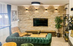 salon z zieloną kanapą i telewizorem w obiekcie 2 Bedroom Gorgeous Home In Mirkovci w mieście Vinkovci