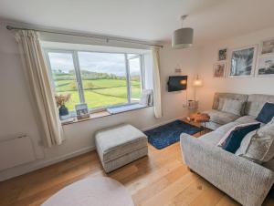 a living room with a couch and a large window at Charming Cottage with Stunning Views in Calstock