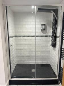 a shower with a glass door in a bathroom at Beautiful Thatched Cottage with heated outdoor pool, Great for families & Dog Friendly! in Bosham