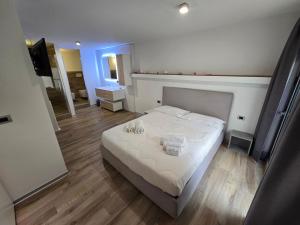 1 dormitorio con 1 cama grande con sábanas blancas en B&B White con Parcheggio Privato, en Porto Cesareo
