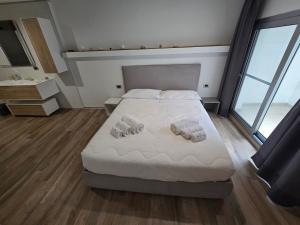 1 dormitorio con 1 cama con 2 toallas en B&B White con Parcheggio Privato, en Porto Cesareo