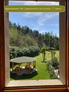 ein Fenster mit Gartenblick und einem Picknicktisch in der Unterkunft Country House Foglie d'erba in Calavino