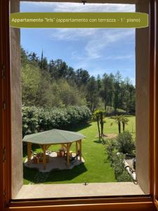 a window view of a garden with a picnic table at Country House Foglie d'erba in Calavino