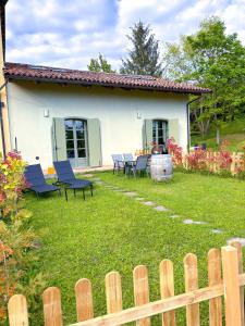 ein Haus mit Stühlen und einem Tisch im Hof in der Unterkunft Just Langhe Casa Nebbiolo in Novello