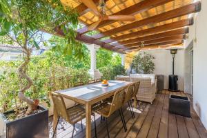 une terrasse en bois avec une table et des chaises. dans l'établissement Duplex Marbella Concordia Close To Beach, à Marbella