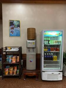 a refrigerator freezer sitting next to a shelf with drinks at Heuang Paseuth Hotel 香帕赛酒店 in Luang Prabang