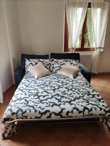 un letto con piumone blu e bianco e 2 cuscini di Appartamento a Colle Val d'Elsa a Colle Val D'Elsa