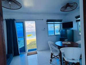 a dining room with a table and chairs and a window at 1888 Beach Resort in Dumaguete