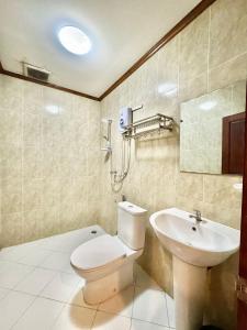 y baño con aseo y lavamanos. en Heuang Paseuth Hotel 香帕赛酒店 en Luang Prabang