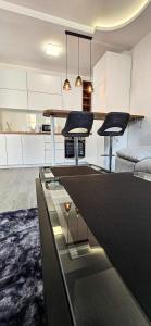 a kitchen with a table and two stools at Apartman Spaß in Šabac +8 photos