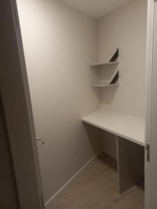 a white walk in closet with a desk and shelves at Casinha de Santo Amaro in Ourém