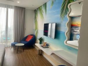 a hotel room with a bedroom with a palm tree mural at Flamingo Hải Tiến in Thanh Hóa
