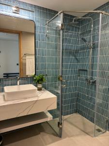 a bathroom with a shower and a sink and a mirror at Flamingo Hải Tiến in Thanh Hóa