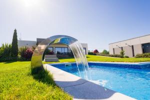 una piscina con una fuente de agua en un patio en Hotel A Curuxa Wellness, en Arzúa