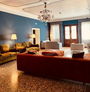 a large living room with a couch and a chandelier at Villa Ca' Damiani Rooms & Apartments in Caneva