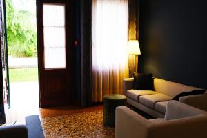 - un salon avec un canapé, des chaises et une porte dans l'établissement Villa Ca' Damiani Rooms & Apartments, à Caneva