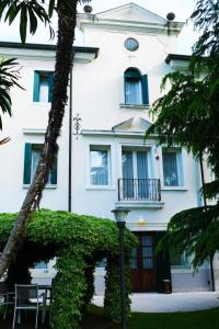 un edificio blanco con una mesa delante en Villa Ca' Damiani Rooms & Apartments, en Caneva