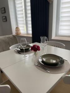 uma mesa branca com dois pratos e taças de vinho em LA ROCHE em Verdun-sur-Meuse