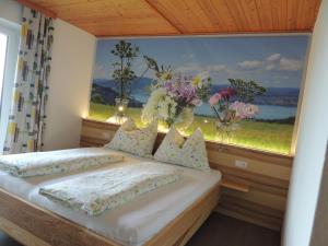 Un dormitorio con una cama y una ventana con flores. en Ferienwohnungen Schöbringer, en Weyregg