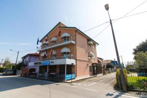 ein braunes Gebäude mit Balkonen auf einer Straße in der Unterkunft BlueColors Hotel ex Hotel Lucy in Campalto