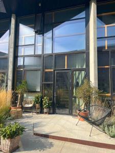 un edificio con puertas de cristal y plantas en un patio en Large house in New York style with a private rooftop terrace., en Copenhague