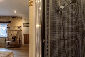 a shower in a room with a glass wall at Le Lys Dort Sarlat in Sarlat-la-Canéda
