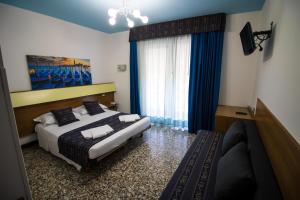 a bedroom with a bed and a couch and a window at BlueColors Hotel ex Hotel Lucy in Campalto
