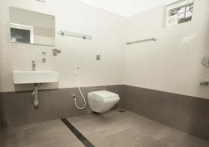 a bathroom with a toilet and a sink at Vythiri Silver Mist by VOYE HOMES - Hill Top Private Villa in Wayanad in Vythiri