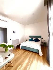 una camera da letto bianca con un letto e un tavolo di 49 Downtown Pompeii a Pompei