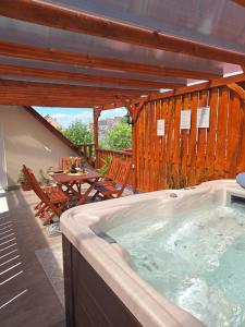 a hot tub on a patio with a table and chairs at Várfal apartman II in Eger