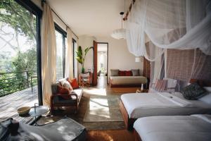 a bedroom with two beds and a balcony at Kaliwa Lodge in Moshi