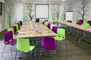 a conference room with long tables and purple chairs at Hotel Albert 1er in Rueil-Malmaison