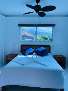 a blue bedroom with a bed with a ceiling fan at 1888 Beach Resort in Dumaguete