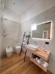 un bagno con lavandino, water e specchio di 49 Downtown Pompeii a Pompei