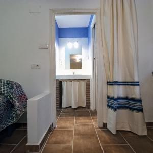 a bathroom with a shower curtain and a sink at El Cortijo de Marie in Granada