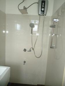 ein Bad mit einer Dusche mit einem Duschkopf in der Unterkunft Ananthaya -the infinity in Kalutara
