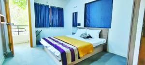 Un dormitorio con una cama con paredes azules y una ventana en TULSI VILLA- The Holiday Home, en Nashik