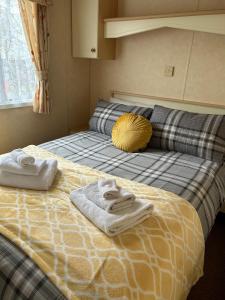 a bedroom with a bed with towels on it at Curacao Caravans in Taynuilt