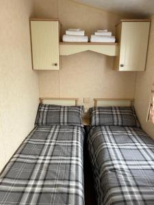 two beds sitting next to each other in a room at Curacao Caravans in Taynuilt