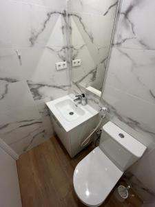 La salle de bains blanche est pourvue de toilettes et d'un lavabo. dans l'établissement Precioso apartamento cerca de la playa en Villajoyosa, à La Vila Joiosa