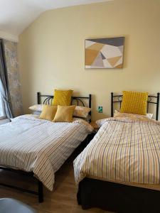 dos camas sentadas una al lado de la otra en un dormitorio en The New Inn, en Cinderford