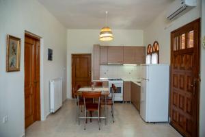 a kitchen with a table and a white refrigerator at Horizon view house in Sozopoli
