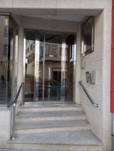 a staircase leading to a building with glass doors at Dúplex c/Álvaro Cunqueiro 1-3-C1 in Foz +12 photos