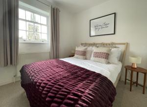 a bedroom with a large bed with a purple blanket at Apartment 4 St Georges in Cheltenham