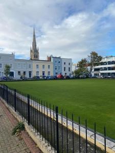 un grande edificio bianco con un grande prato erboso di Apartment 4 St Georges a Cheltenham